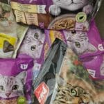 • Različiti paketi hrane za mačke složeni na podu – primjer svakodnevnog izbora u ishrani