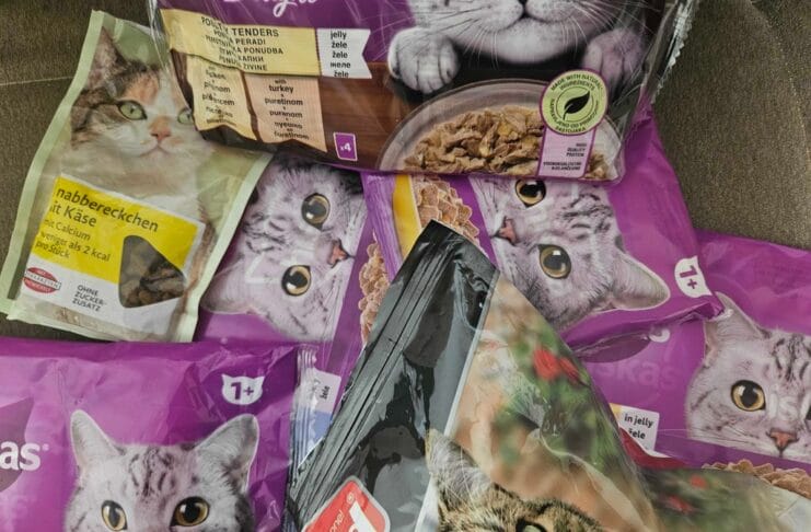 • Različiti paketi hrane za mačke složeni na podu – primjer svakodnevnog izbora u ishrani