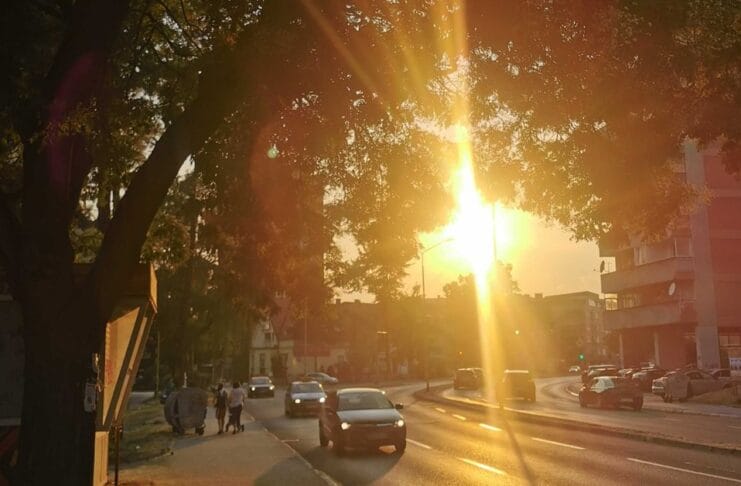 početak ljeta 2025. ljeto, tuzla. Zalazak sunca kroz gradsko drveće u Tuzli tokom ljeta