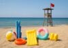 Sigurno kupanje na plaži ilustrirano rekvizitima za plivanje i crvenom zastavom pored spasilačke kućice.