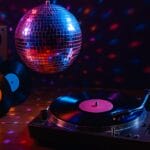 ultimativni plesni hitovi 70-ih i 80-tih, Retro disko scena sa vinil pločama, gramofonom i disko kuglom u vibrantnoj atmosferi plesnog podija 70-ih i 80-ih