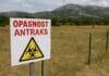 Antraks u Hrvatskoj, Znak upozorenja na antraks ispred ograđenog pašnjaka u Dalmatinskoj zagori, uz planinski pejzaž u pozadini.