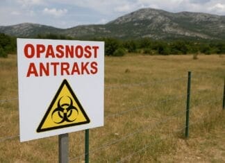 Antraks u Hrvatskoj, Znak upozorenja na antraks ispred ograđenog pašnjaka u Dalmatinskoj zagori, uz planinski pejzaž u pozadini.