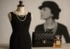 Mala crna haljina na manekenu s biserima, uz Chanel torbicu i parfem No. 5, u pozadini zamućena crno-bijela fotografija Coco Chanel.