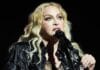Madonna na pozornici u crnoj kožnoj jakni i s akustičnom gitarom